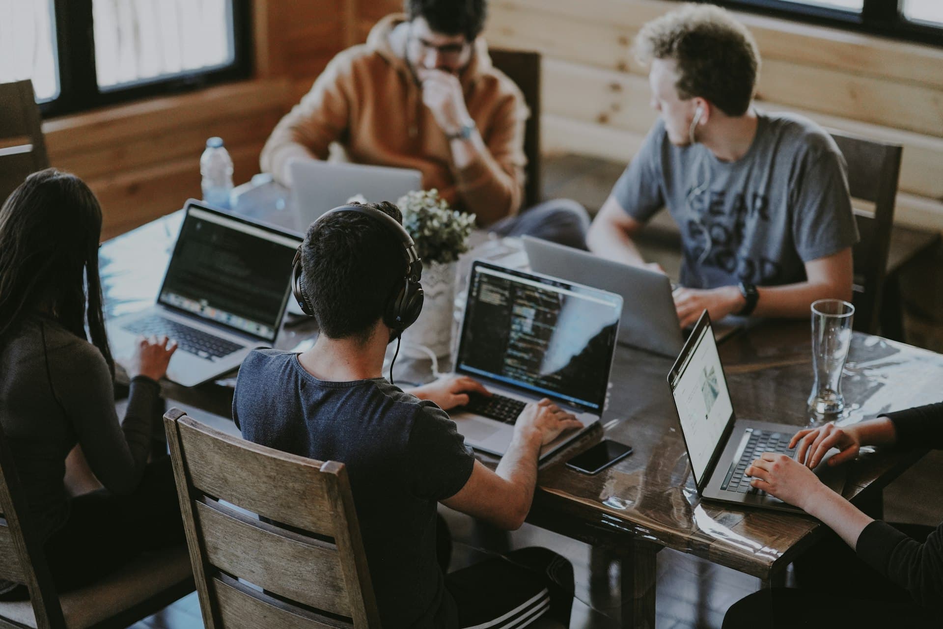 Young people working on laptops in a collaborative digital workspace